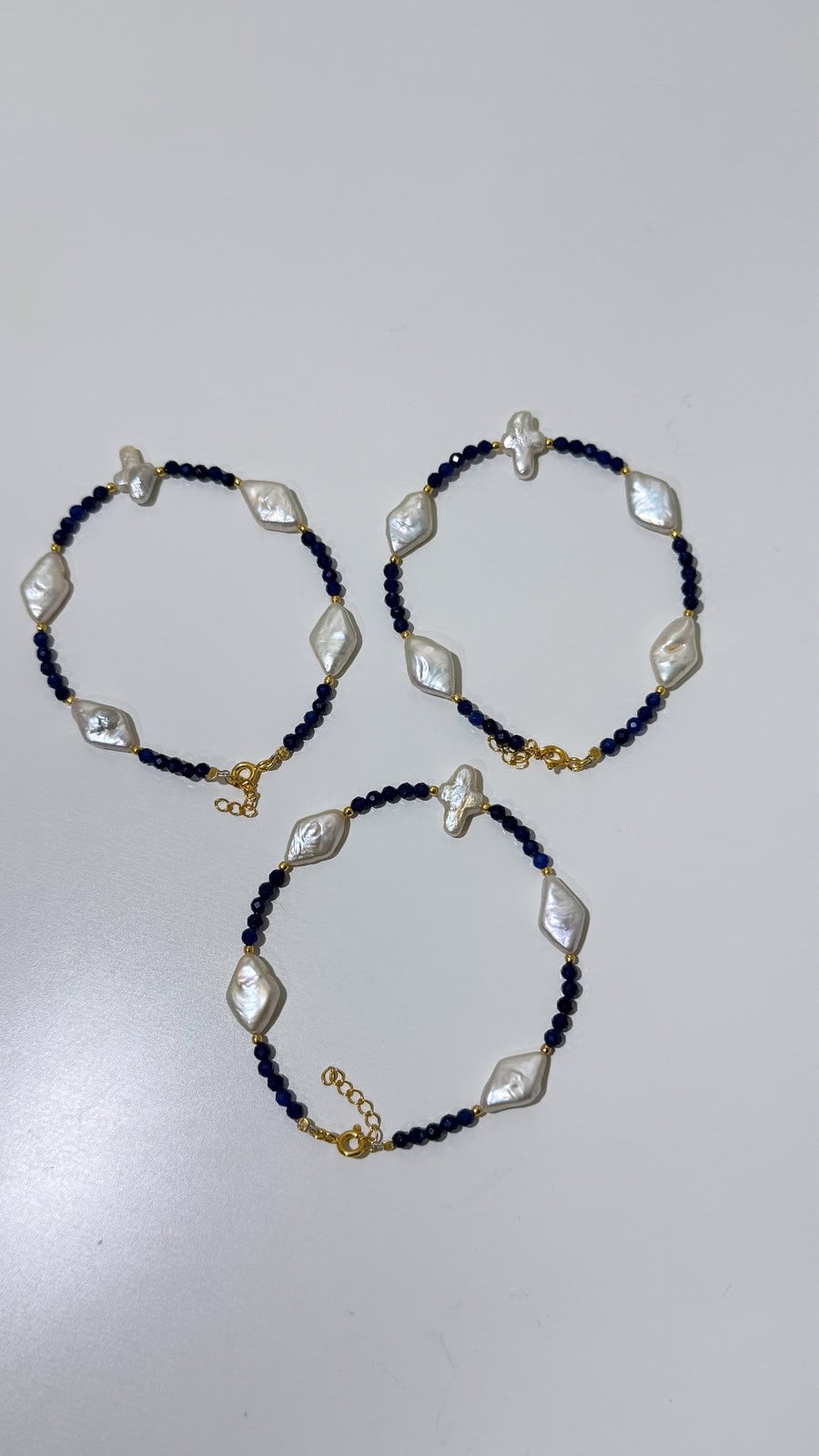 Three bracelets of baroque pearls and dark beads